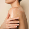 A woman rubbing in the Purifying Cream Oil Body Wash from The Retreat