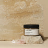 The invigorating Body Polish from The Retreat displayed on a stone