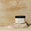 The Retreat Nourishing Body Butter on a stone display