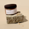 The Retreat body Invigorating Body Polish and swatch on a stone